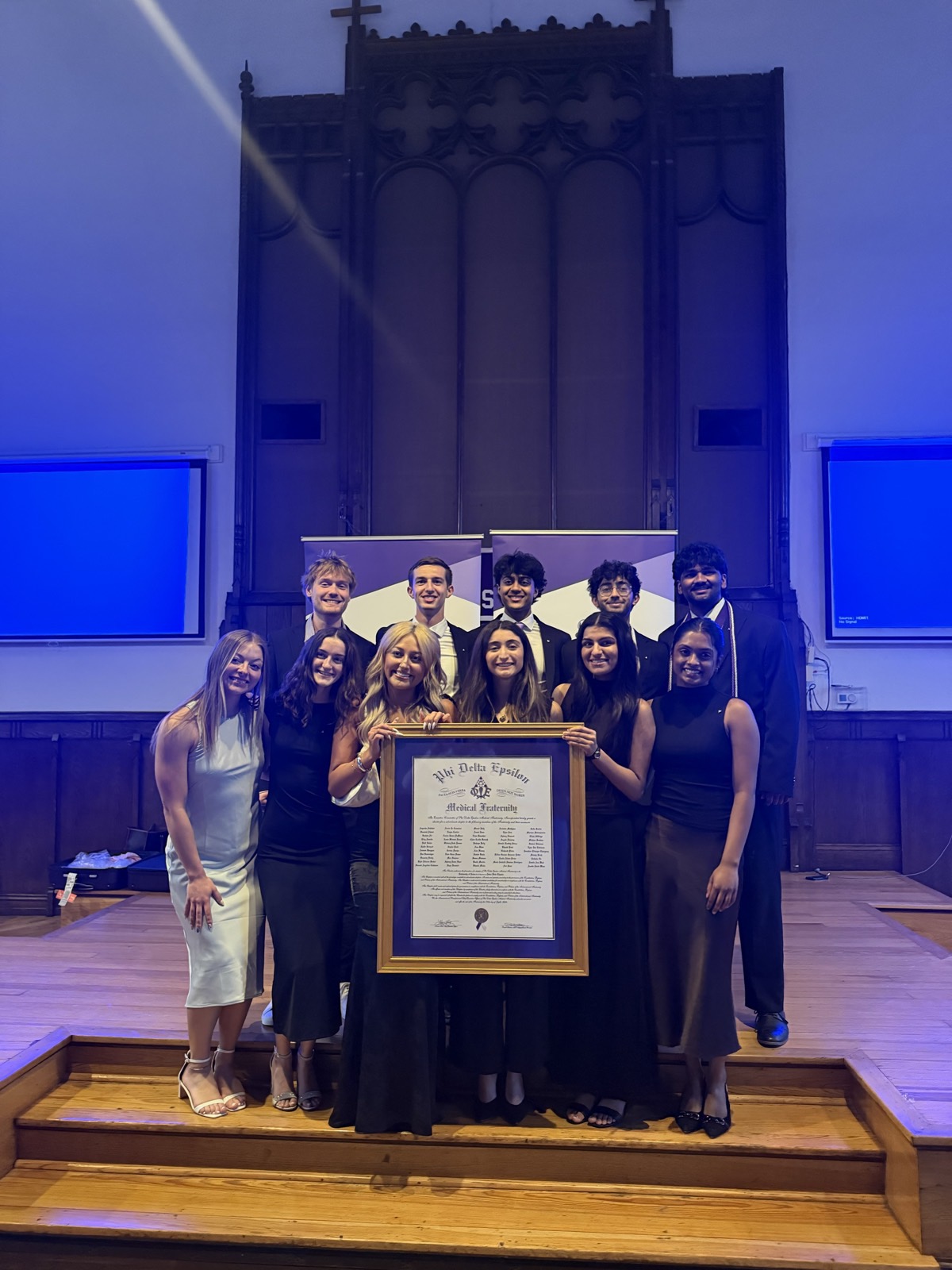 The Iowa Beta executive board holding the chapter charter